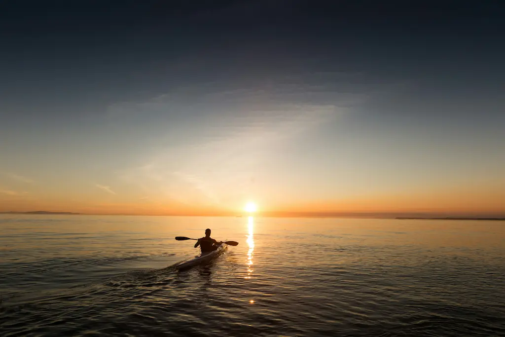 Kayak en mer au coucher du soleil.
