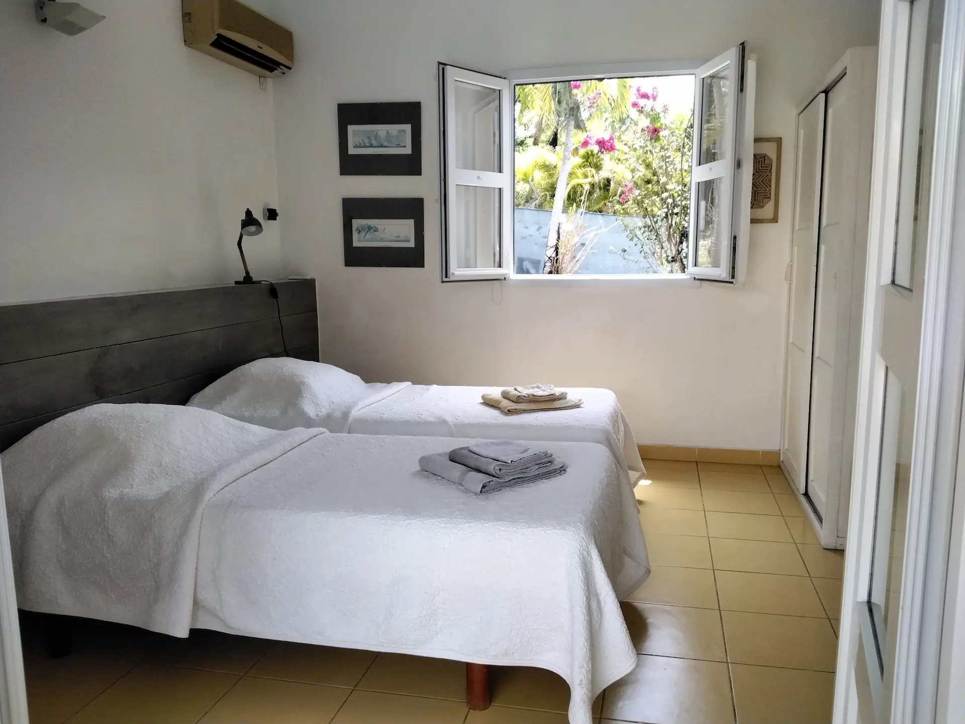 Habitation de l'anse mancenillier, chambre avec deux lits simples avec vue par la fenêtre, sur le jardin