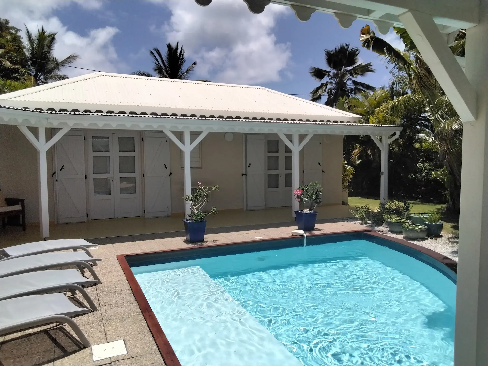 Piscine et terrasse ensoleillée devant un bungalow créole à l’Habitation de l’Anse Mancenillier à Saint-François en Guadeloupe